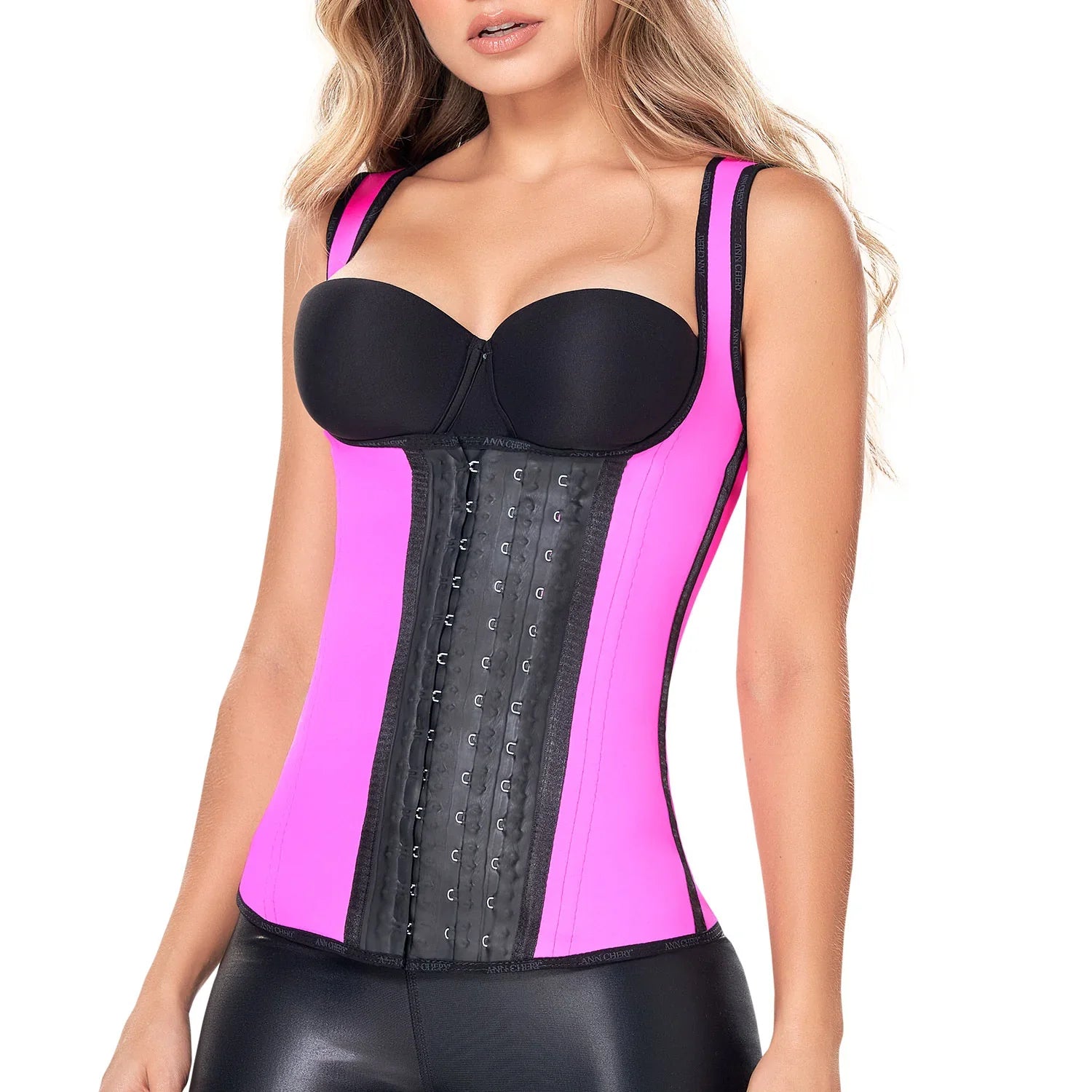Woman wearing a pink latex waist trainer vest with three rows of black hook closures